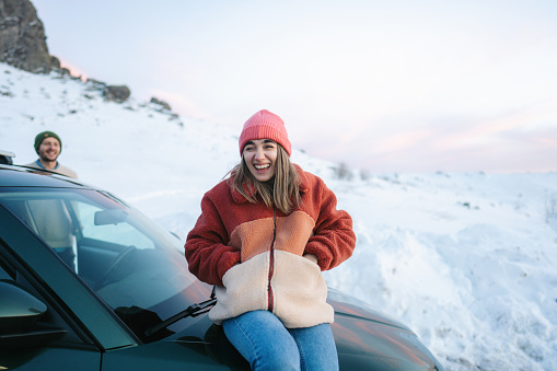 Photo of a smiling couple on a winter road trip