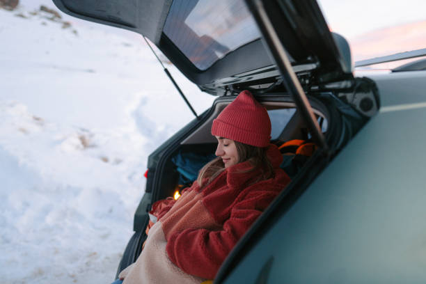 istock Young woman daydreaming while on a winter road trip 1705696067