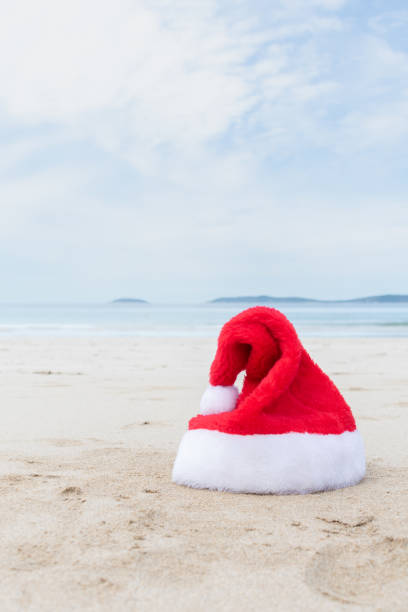 istock Christmas hat on a towel at the beach. Copy space. 1705702193