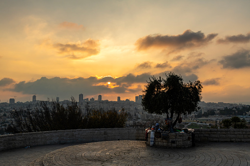 Sunset at a viewpoint overlooking Jerusalem with souvenir seller set up under a tree in Israel.