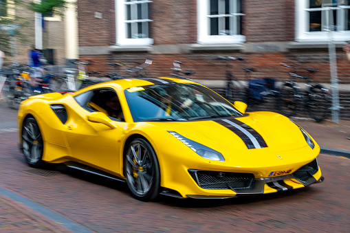 Ferrari 488 Pista sports car in the streets of Zwolle. The Pista is a high performance version of the Ferrari 488 GTB sports car. Panning photo with heavy motion blur.