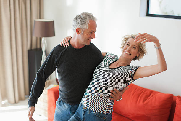 Mature couple dancing in living room  middle aged couple dancing stock pictures, royalty-free photos & images