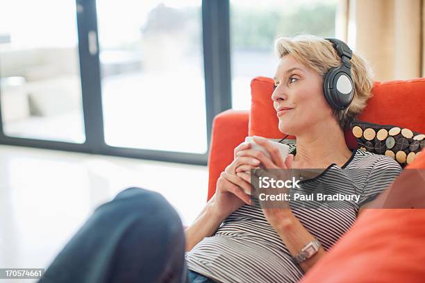 Foto de Mulher Tomando Café E Escutando Fones De Ouvido e mais fotos de stock de Fone de Ouvido - Equipamento de som - Fone de Ouvido - Equipamento de som, Escutar, Música