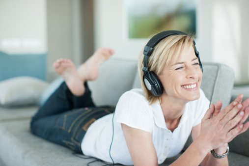 Happy young asian woman wearing headphones listening music while dancing and singing with fun and enjoy in the living room, happiness female with entertainment, one person, lifestyles concept.