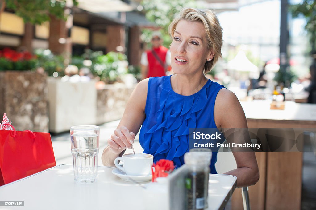 Donna bere il caffè nella caffetteria - Foto stock royalty-free di 45-49 anni