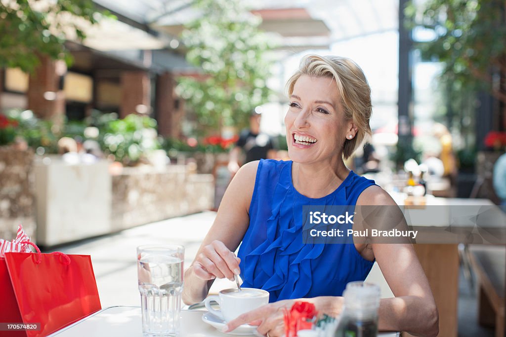 Mujer bebiendo café en Café - Foto de stock de 45-49 años libre de derechos