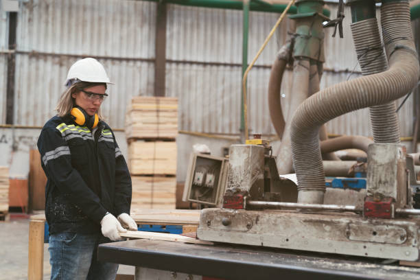 istock Female carpenter factory worker using wood rolling machine for process timber at manufacturing lines in wooden warehouse storage plant 1705756040