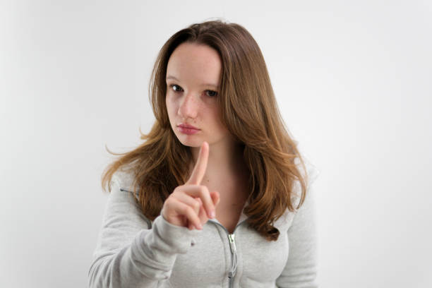 jeune belle fille adolescente leva l’index alerte pense être attentif avoir une idée écoutez-moi elle porte un survêtement sur fond blanc cheveux bruns européens - thumbs up human thumb human finger brown hair photos et images de collection