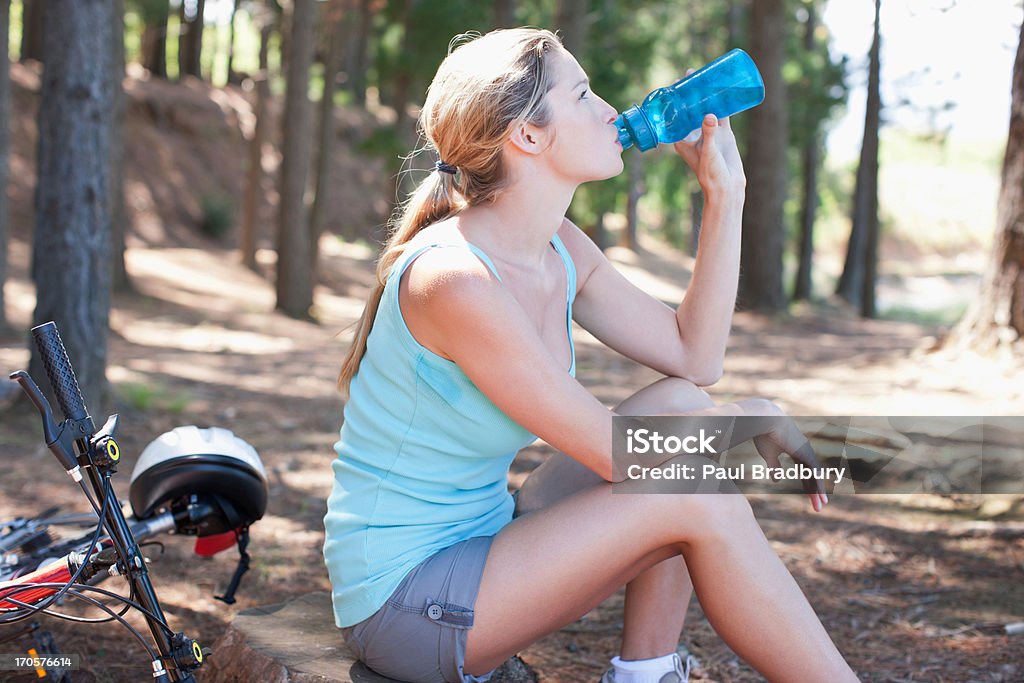 Mujer agua potable en el bosque - Foto de stock de Agua potable libre de derechos