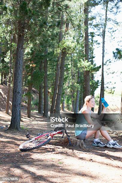 Kobieta Wody Pitnej W Lesie - zdjęcia stockowe i więcej obrazów 25-29 lat - 25-29 lat, Bicykl, Butelka