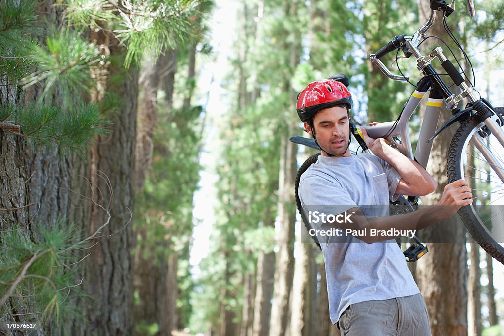 Homem Carregando bicicleta em uma floresta - Foto de stock de Bicicleta royalty-free