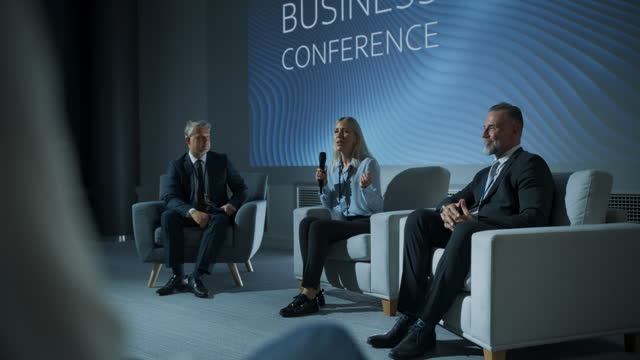 International Business Conference: Host Asking Caucasian Female Tech CEO a Question In Front Of Audience Of Diverse Attendees. Successful Woman Delivering Inspirational Speech For Women In Leadership.