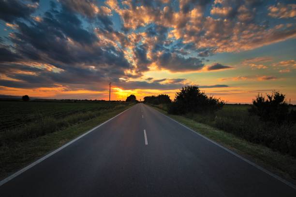 istock Scenic landscape with an open, empty road with billowing clouds in the sky above 1705782355
