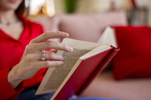 A mid adult Caucasian woman reading a book at home