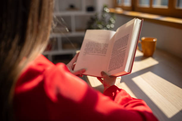 istock Woman reading a book at home 1705802878