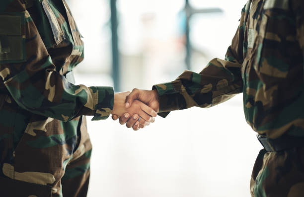 istock Mission, army or shaking hands for partnership, teamwork or deal in war, agreement or unity together. People, soldiers or handshake for team fight, thank you or gratitude in solidarity or military 1705803686