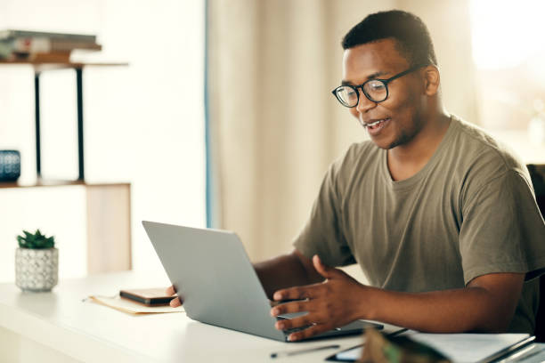 istock Laptop, man and smile for remote work, research or copywriting in home office with happiness and glasses. Computer, employee and person working or reading project online with internet or connectivity 1705803719