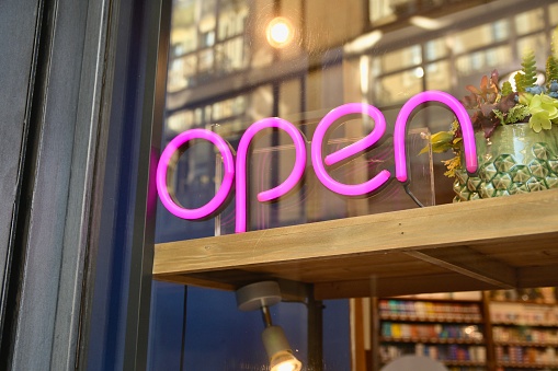 Open storefront pink neon sign