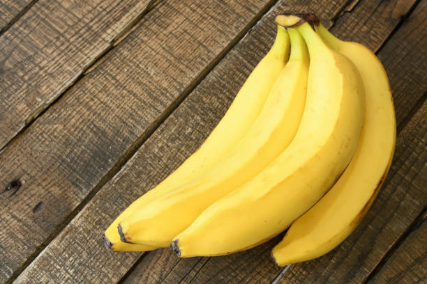 istock Fresh bananas on wooden background 1705806226