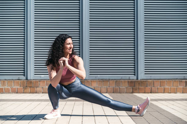 istock Young smiling fit woman doing stretching exercises for legs before training 1705809138