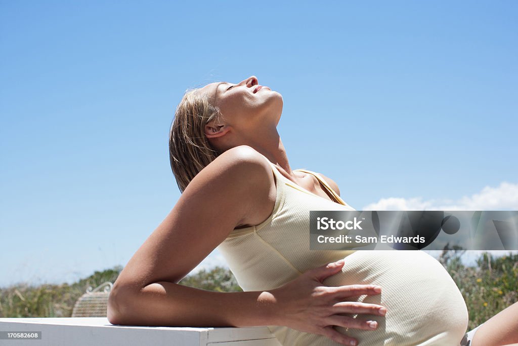 Donna incinta holding stomaco - Foto stock royalty-free di 25-29 anni