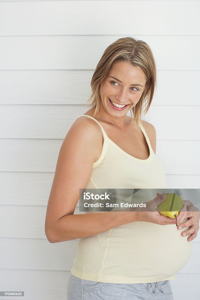 Mulher grávida segurando pera - Foto de stock de Grávida royalty-free