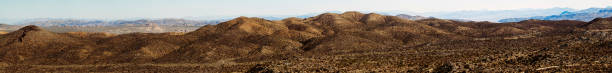 Part two of an extremely large panoramic shot of the Joshua Tree National Monument which can be merged with the first part for an extremely large panoramic shot of the scenic mountains and dry climate with a clear blue and sunny sky behind it.