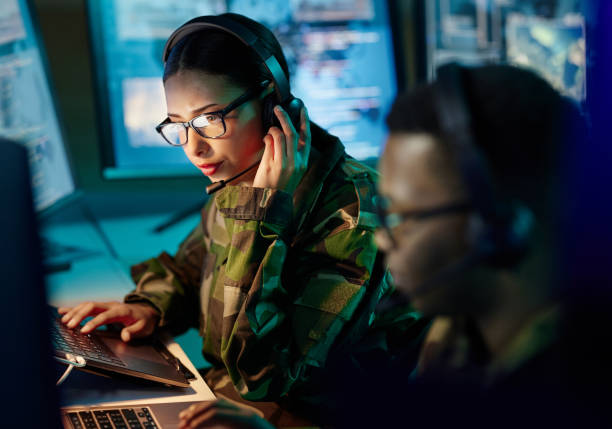 istock Military control room, headset and woman with communication, computer and technology. Security, global surveillance and soldier with teamwork in army office at government cyber data command center. 1705832697