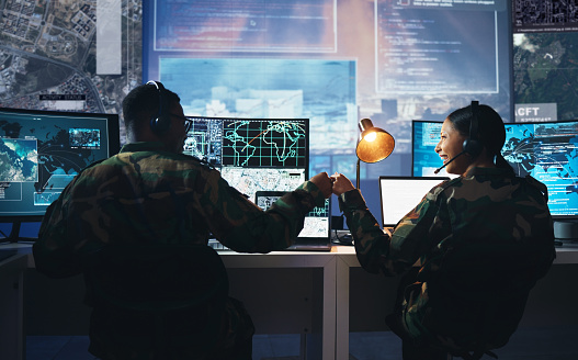 Control room, military and fist bump by soldier team on surveillance together at night for communication. Technology, global and teamwork by security with success on satellite map in army office