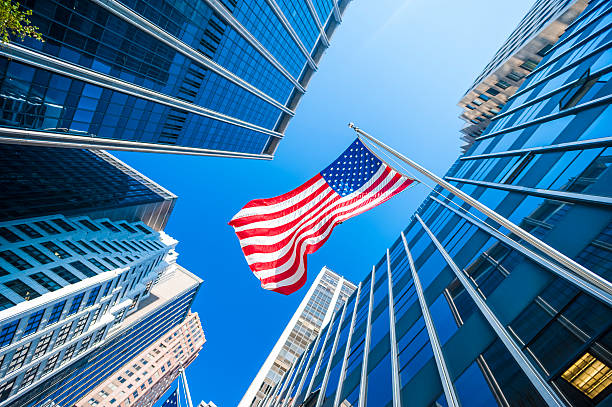 USA flag and contemporary glass skyscrapers in New York USA flag and contemporary glass architecture of Financial District, New York City, USA. american architecture stock pictures, royalty-free photos & images