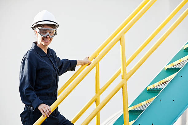 Industrial worker climbing metal staircase