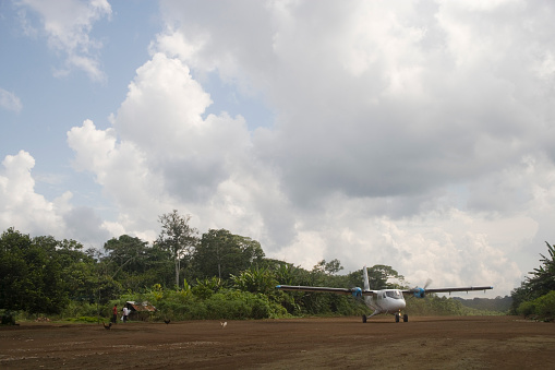 Kusutkau, Ecuador - April 3, 2006: Aeroplane and dirt landing strip at Kusutkau near Kapawi Ecolodge in the Orient Region of Ecuador, South America