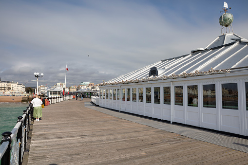 Modern architecture café at the end of Southend Pier in the River Thames estuary. with view back to towards town in the distance. Outdoors on a sunny autumn day. Many people walking and sitting. Southend on Sea, Essex, United Kingdom, September 14, 2020