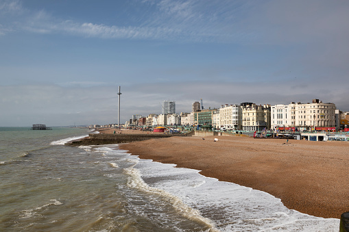 Brighton, United Kingdom - Sep 26, 2023:  Seafront and beach at Brighton in East Sussex, England. Viewed from the pier with British Airways i360 observation tower.