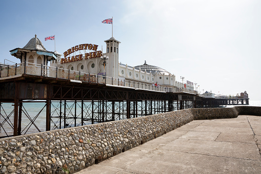 Views of the pier in Brighton on a sunny summers morning. The pier is shot from underneath for a different perspective. Brighton Palace Pier Opened in 1899 and home to fairground rides, bars, restaurants and deckchairs to enjoy the sea view.