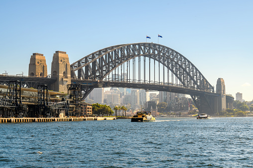 Sydney Harbor Bridge with ferries and Sydney North buildings in the background on a day