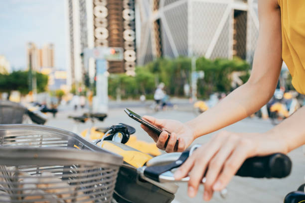 istock An Asian business woman rents a public bicycle using a mobile app while commuting, 1705871435