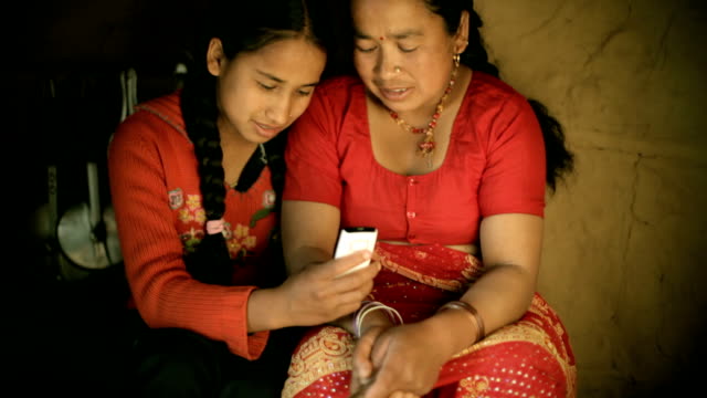 Asian people: Daughter showing mobile phone to her mother
