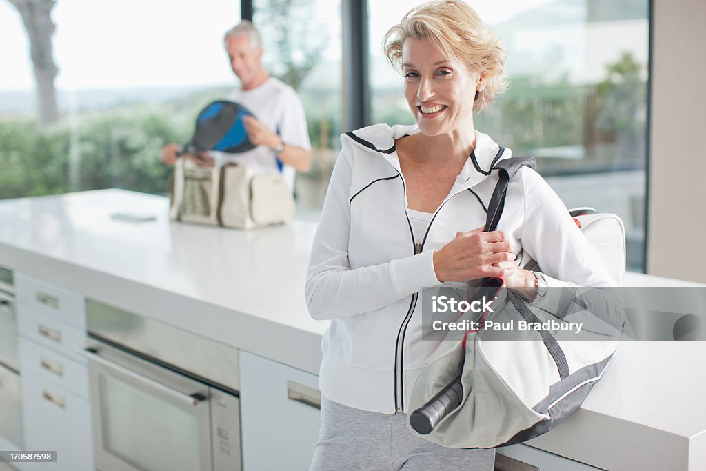 Mujer llevando raqueta de tenis en bolsa de gimnasio - Foto de stock de Tenis libre de derechos