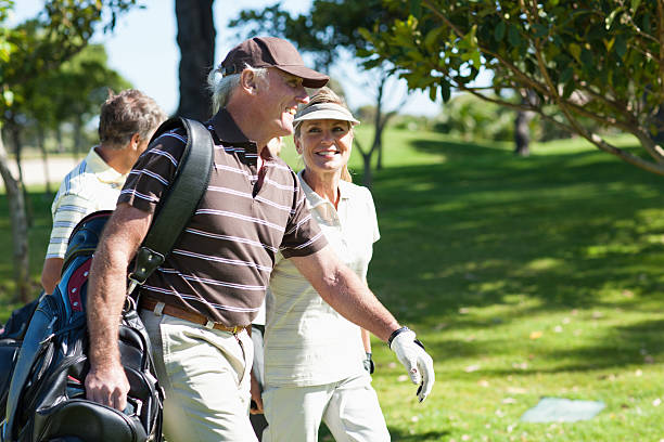 Mature couple carrying golf bags  golfer stock pictures, royalty-free photos & images