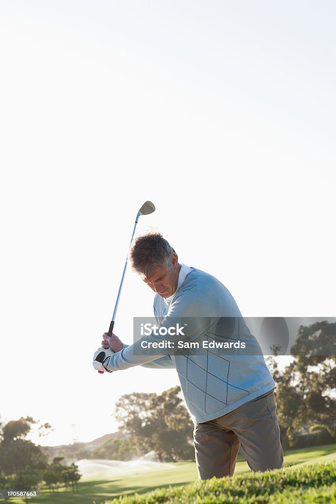 Man playing golf in sand trap  45-49 Years Stock Photo
