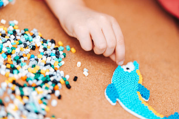 istock Children's creation, assembling animals from plastic pieces. Ironing toy 1705878599