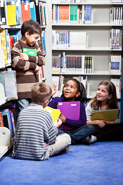 Multiracial children, 6 to 8 years, in school library.