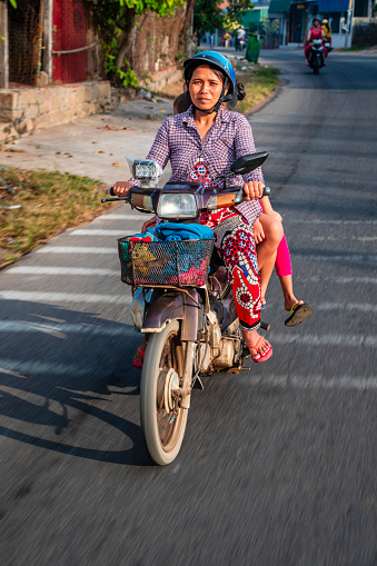 Vietnamese mother with her three children riding a motorbike, South Vietnam