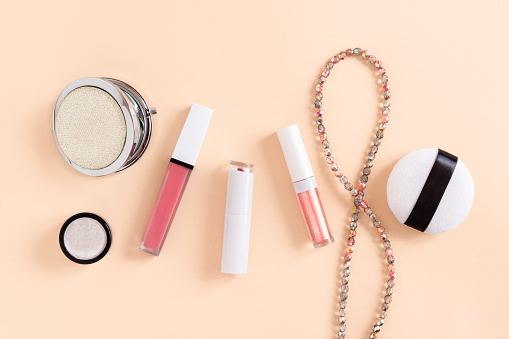 Banner background with flatlay cosmetics on delicate pink background. Makeup accessories lipstick top view in pastel colors copy space.