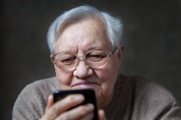 istock Grandmother with glasses looking at smartphone 1705889747