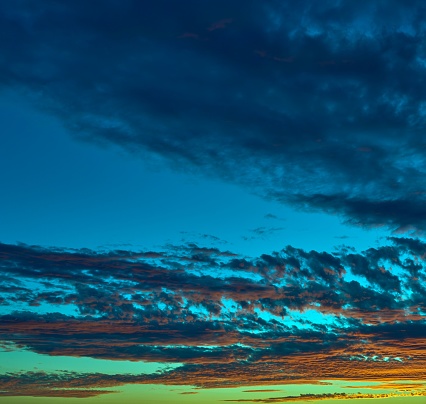 A stunning view of a vibrant sunset sky with a mix of blue hues and billowing clouds