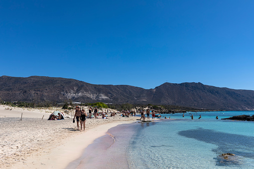 Elafonisi, Crete, Greece - September 13, 2023: Elafonisi is an island located close to the southwestern corner of Crete, near Paleochora. On the beach, people are sunbathing, swimming or walking in the water.