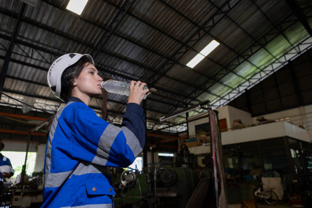 istock Women engineer drinking water from plastic bottle after working at factory during break. Drinking pure water refreshes body. Image female drinking water for advertise. 1705893538