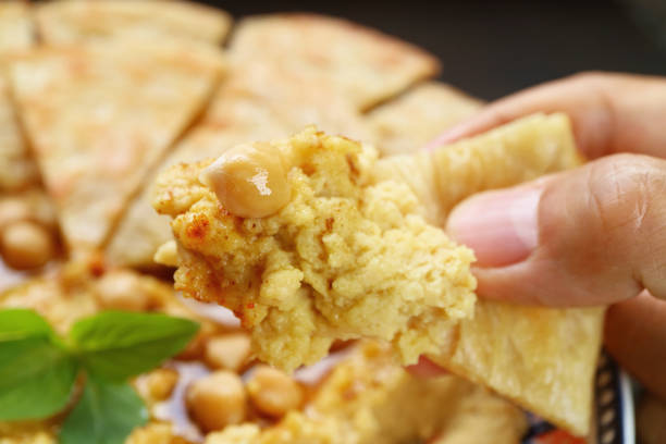 Closeup of Mouthwatering Hummus Dipped with Pita Bread